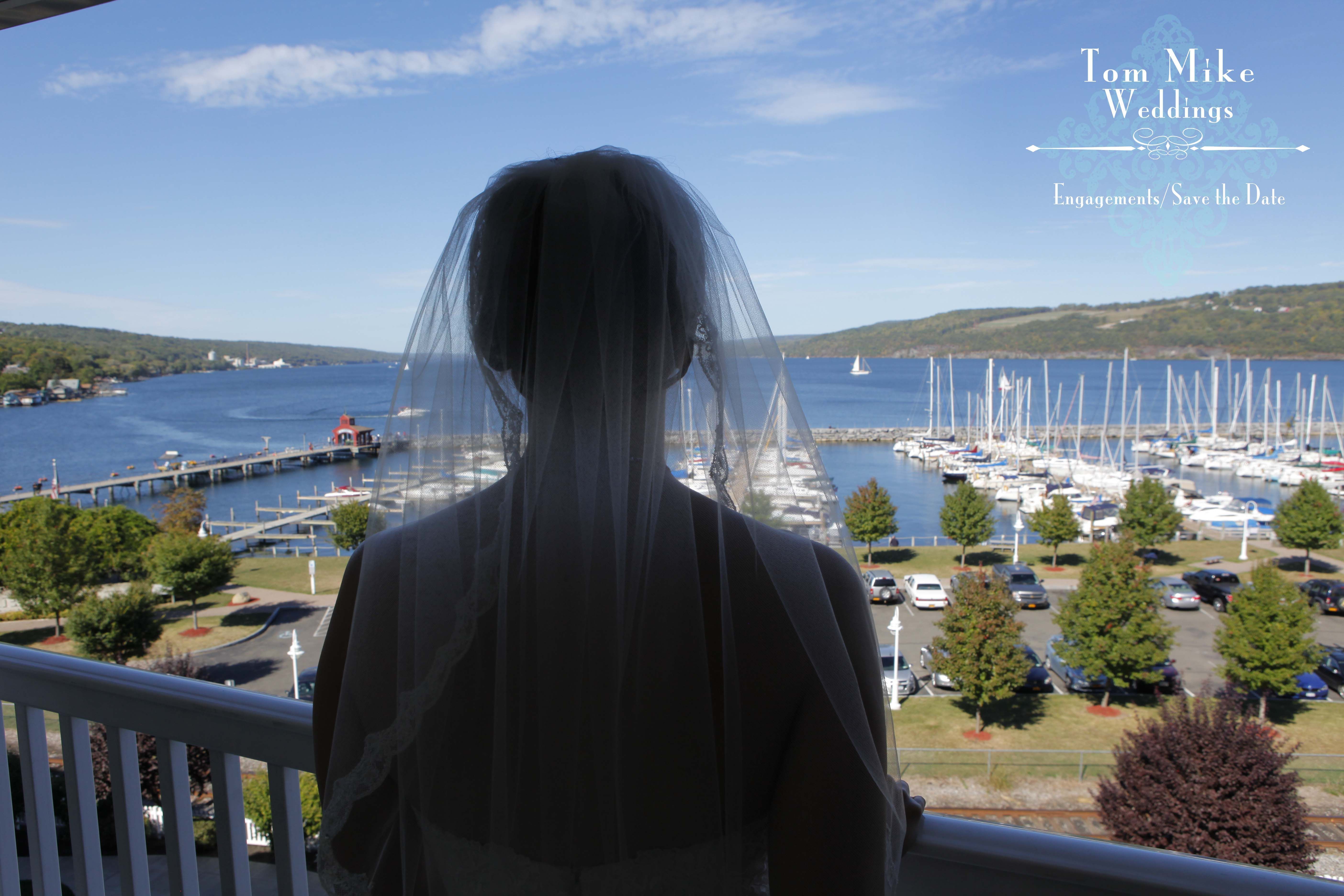 Back of a bride on a balcony overlooking Seneca Lake in Watkins Glen