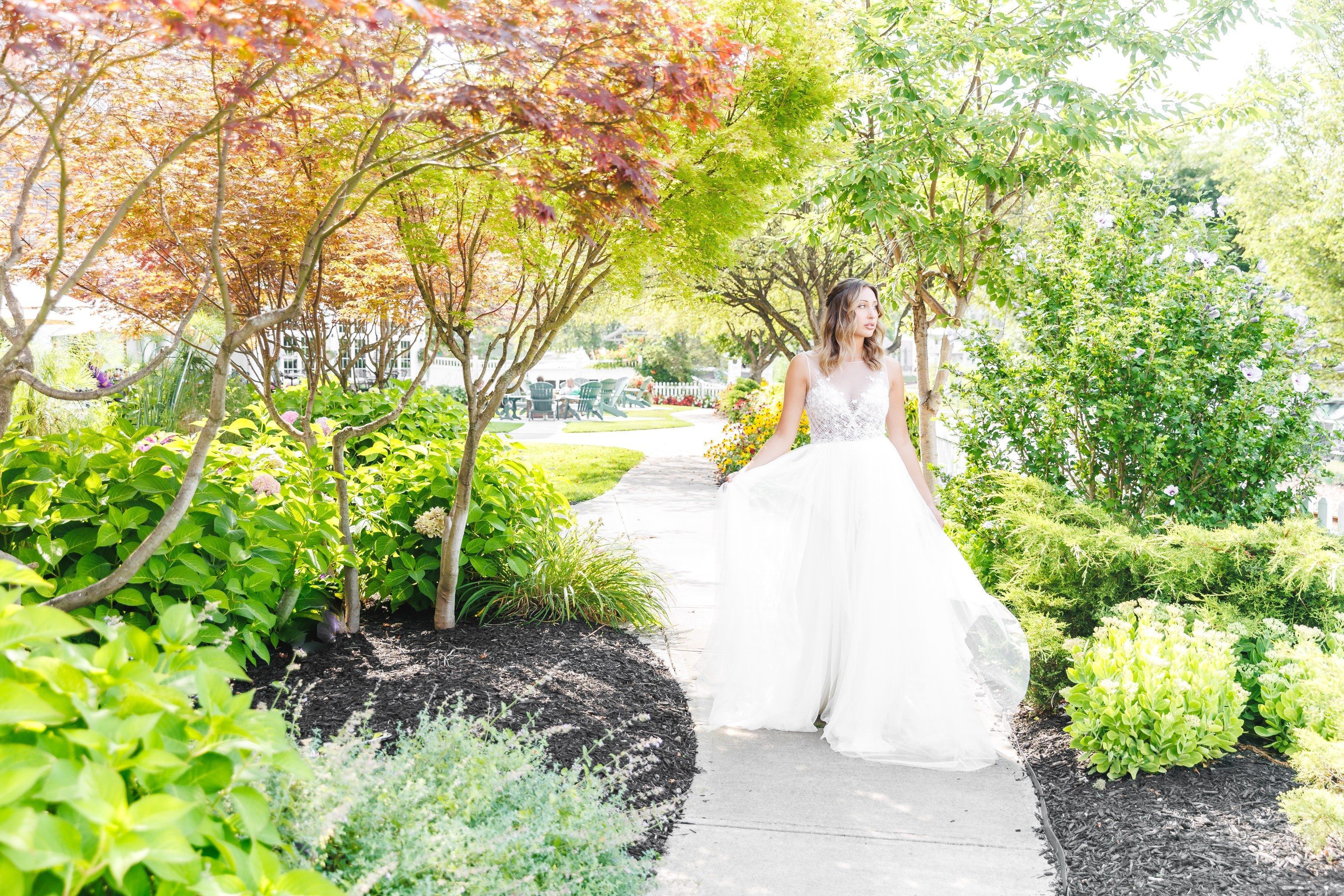 A bride walks down the patio path outside the Watkins Glen Harbor Hotel amid vibrant foliage