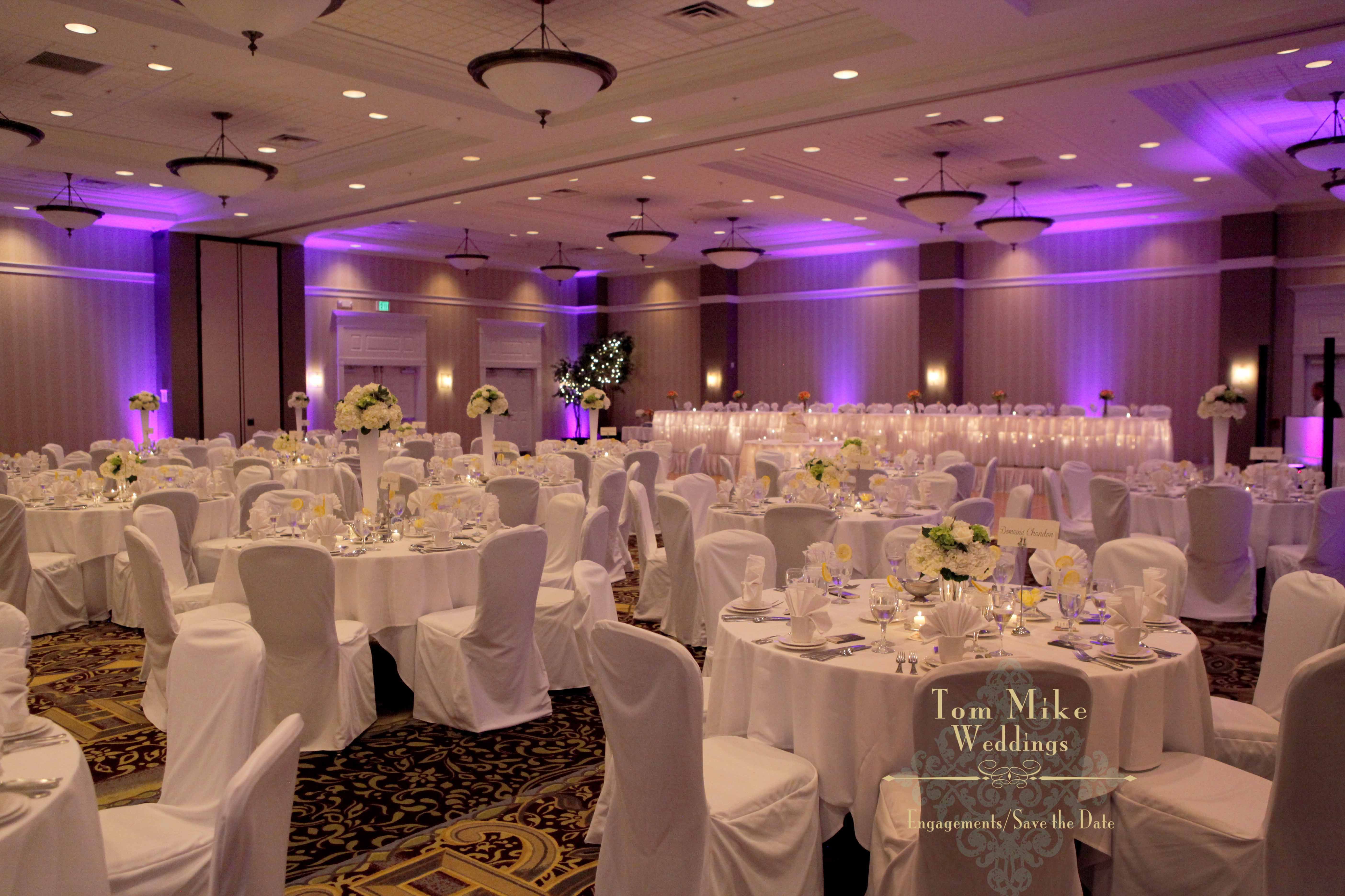 Ballroom setup with white tablecloths and chair covers