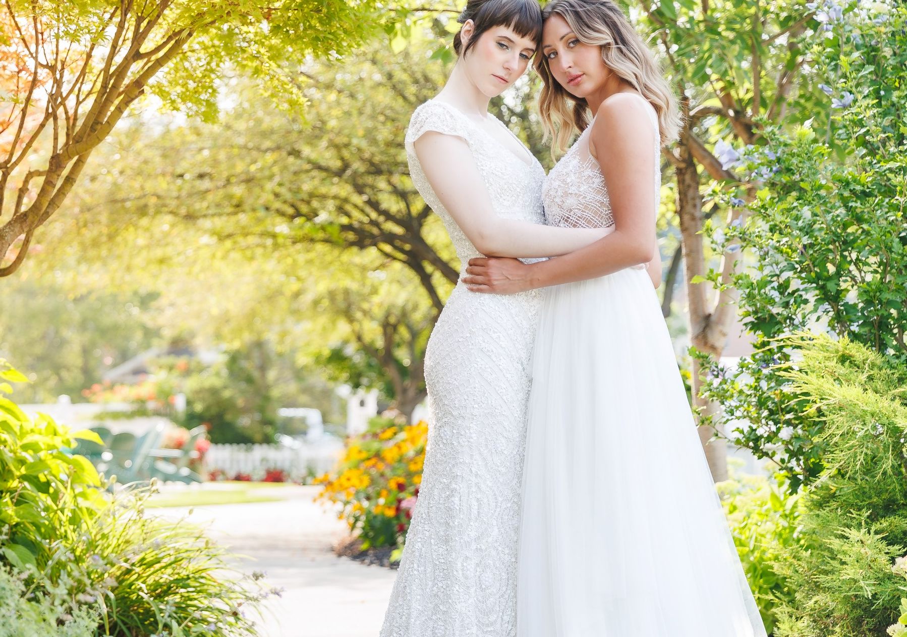 A bridal couple embraces amid vivid green foliage on the path outside the Watkins Glen Harbor Hotel