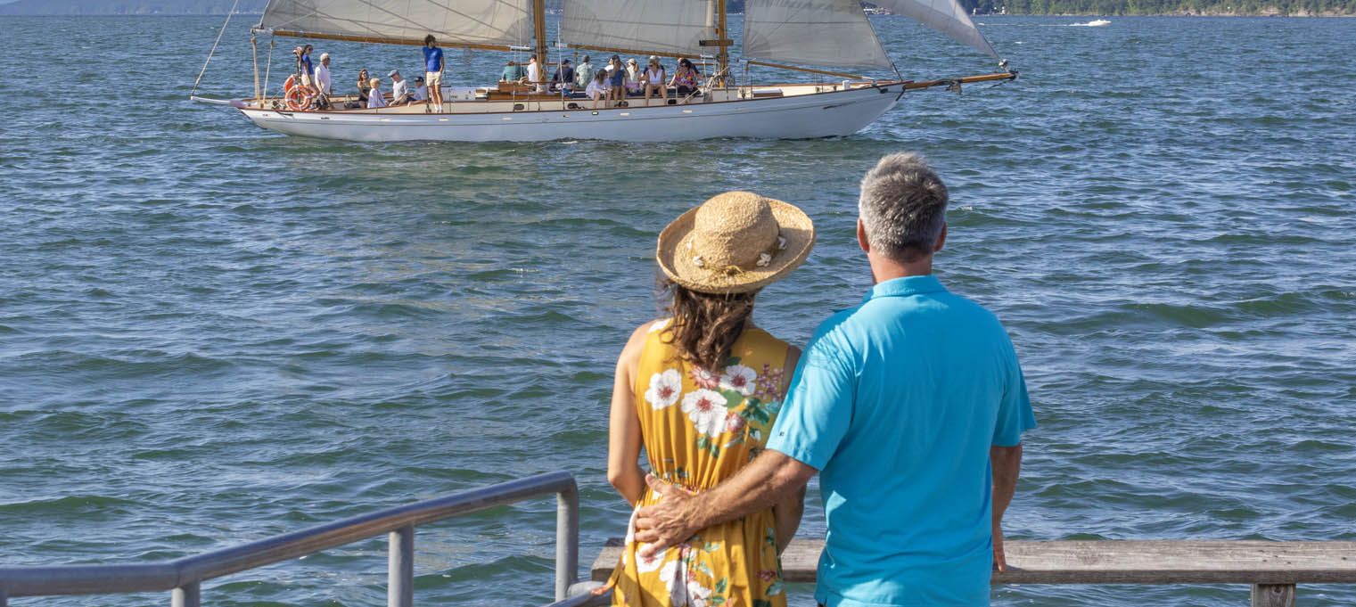 A couple admiring the schooner True Love as it passes by the Watkins Glen Harbor marina jetty